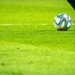 Fudbalska lopta i kopačka na terenu – klađenje na fudbal na startu sezone