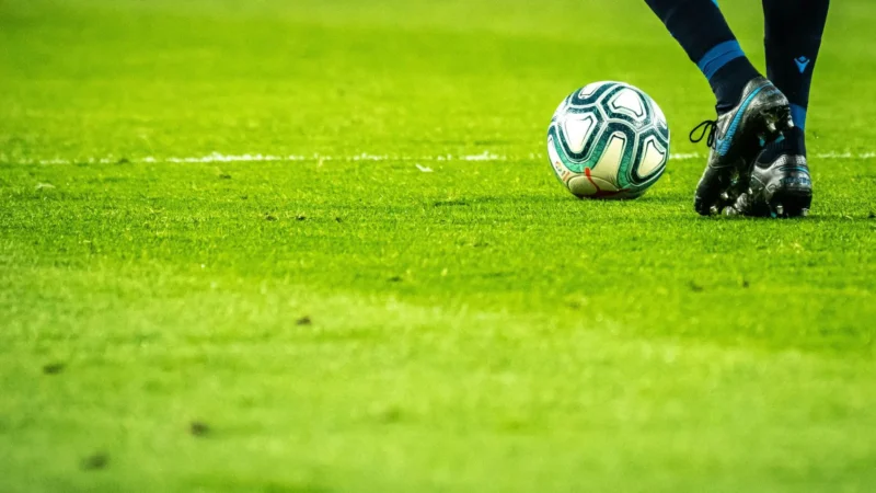 Fudbalska lopta i kopačka na terenu – klađenje na fudbal na startu sezone