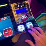 Ruka na osvetljenim dugmadima slot automata – Hold and Win mehanika u slot igrama