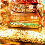 osvetljen slot displej sa neonskim svetlima, novčići i karte za poker u kadru, Las Vegas atmosfera — horizontalna, živopisna