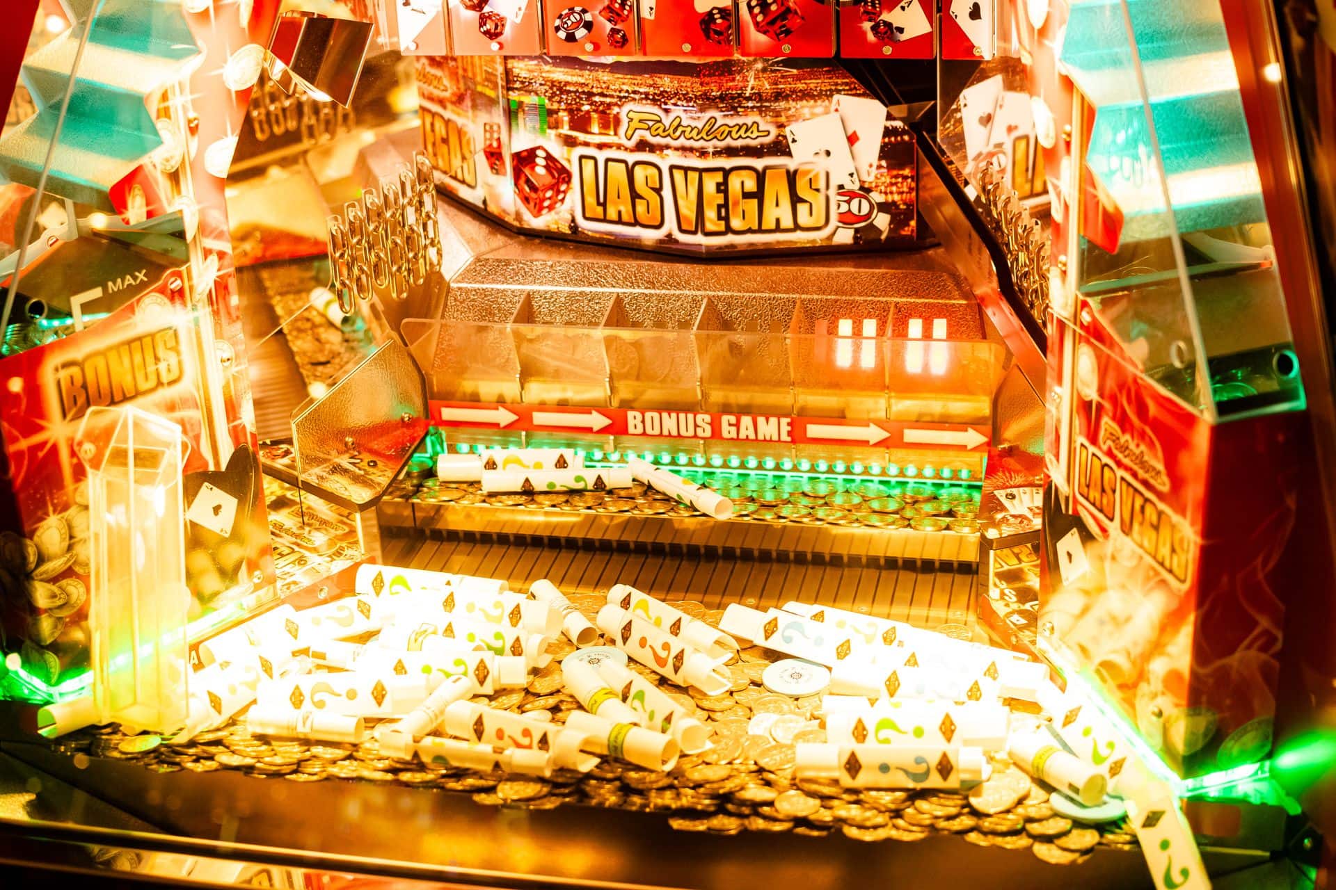 osvetljen slot displej sa neonskim svetlima, novčići i karte za poker u kadru, Las Vegas atmosfera — horizontalna, živopisna
